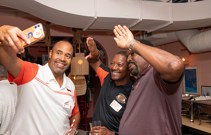 Three alumni take a selfie together